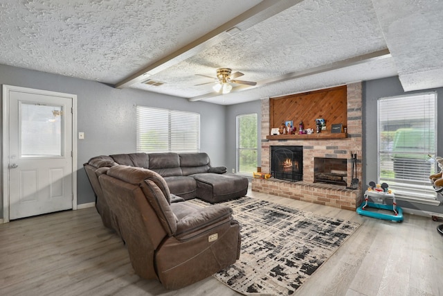 1858 Wood Orchard Dr, Missouri City, TX 77489 - living area featuring visible vents, wood finished floors, a textured ceiling, and a brick fireplace
