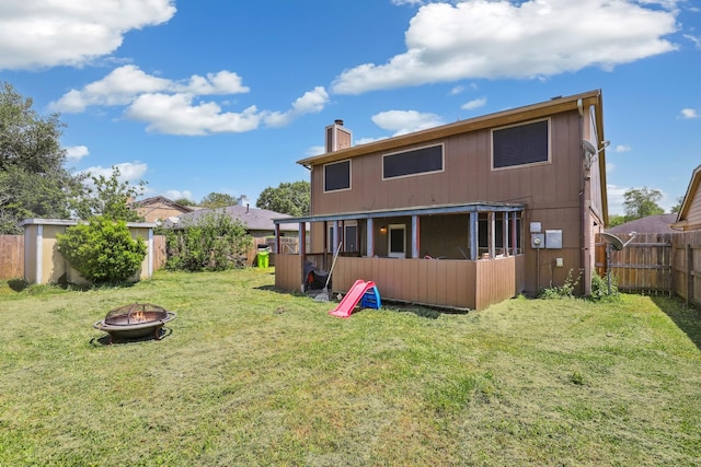 1858 Wood Orchard Dr, Missouri City, TX 77489 - back of house featuring a fire pit, a chimney, a yard, and a fenced backyard