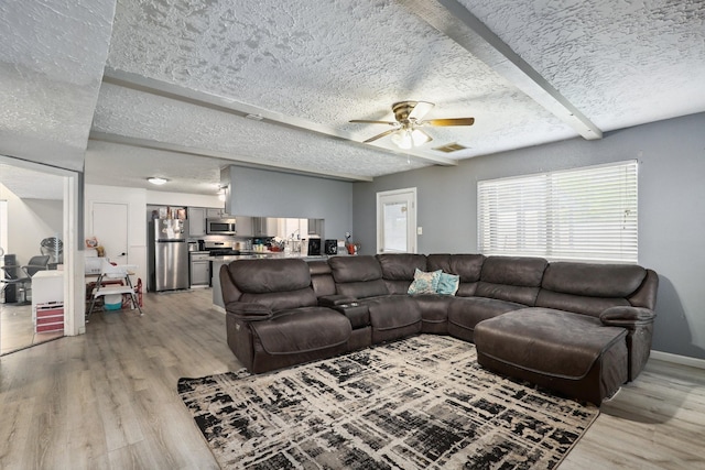1858 Wood Orchard Dr, Missouri City, TX 77489 - living room with visible vents, a textured ceiling, ceiling fan, and light wood finished floors