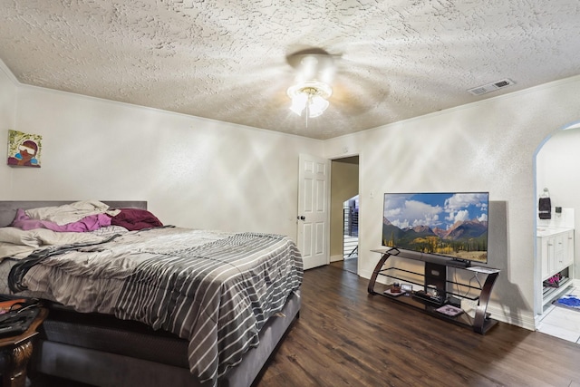 1858 Wood Orchard Dr, Missouri City, TX 77489 - bedroom featuring a textured ceiling, visible vents, wood finished floors, and arched walkways