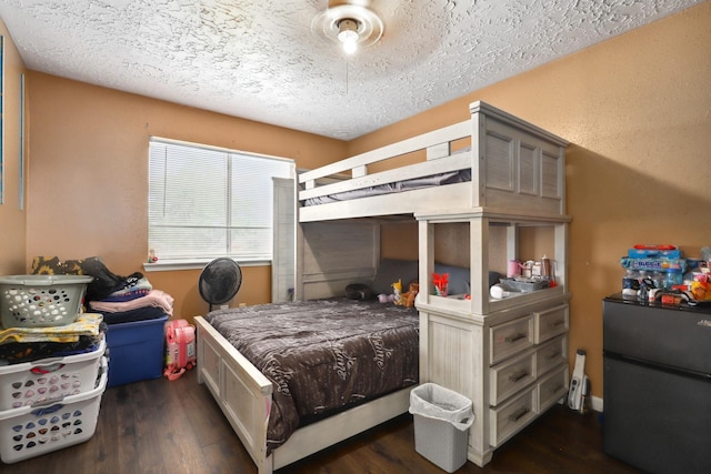 1858 Wood Orchard Dr, Missouri City, TX 77489 - bedroom featuring dark wood finished floors, a textured ceiling, and freestanding refrigerator