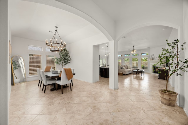 29119 Marina Point Ln, Fulshear, TX 77441 - dining space featuring a ceiling fan, a chandelier, arched walkways, and baseboards