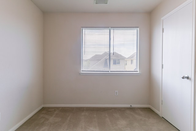 unfurnished room featuring visible vents, baseboards, and light carpet