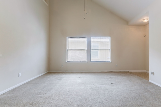 empty room with high vaulted ceiling, baseboards, and light carpet