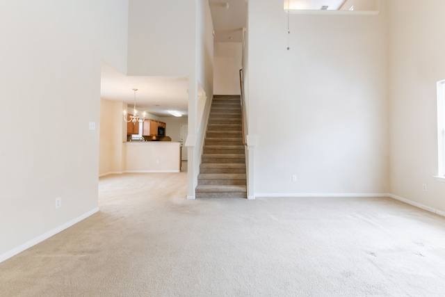interior space with baseboards, a notable chandelier, and carpet flooring