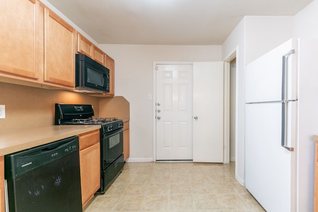kitchen featuring light brown cabinets, light countertops, baseboards, and black appliances