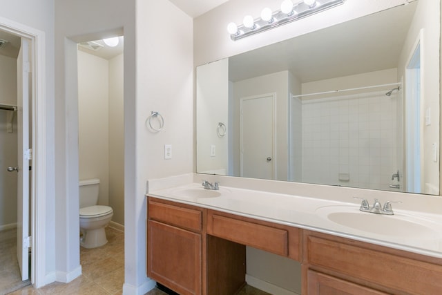 bathroom featuring a sink, a shower, double vanity, and toilet