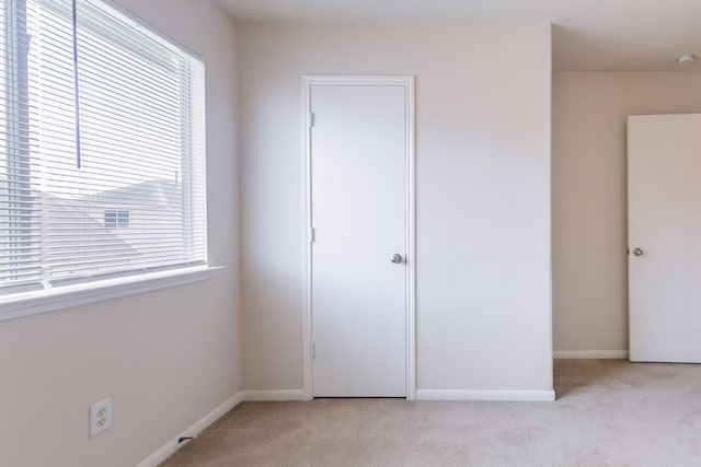 unfurnished bedroom with baseboards and light colored carpet