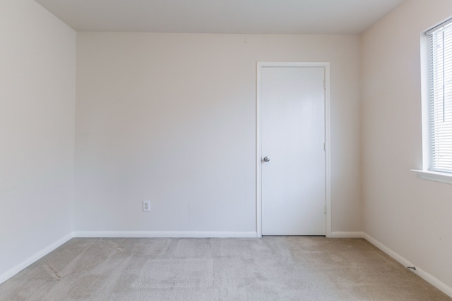 empty room with light carpet and baseboards