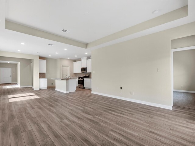 21719 White Bellflower Ln, Cypress, TX 77433 - unfurnished living room featuring recessed lighting, baseboards, visible vents, and light wood-style flooring