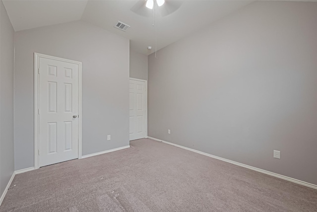 unfurnished bedroom featuring baseboards, lofted ceiling, visible vents, and carpet
