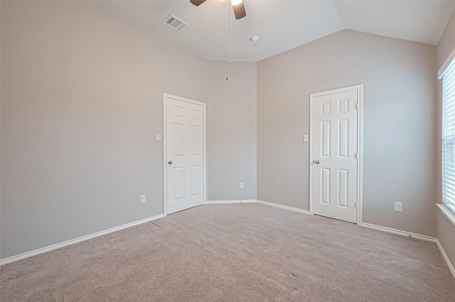 carpeted spare room featuring ceiling fan, lofted ceiling, visible vents, and baseboards
