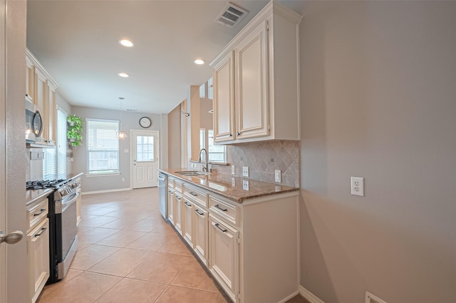 kitchen with recessed lighting, stainless steel appliances, visible vents, a sink, and baseboards