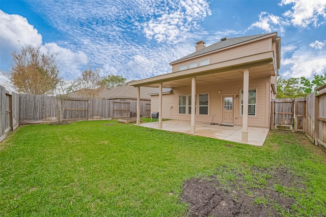 rear view of house with a yard, a patio area, a chimney, and a fenced backyard