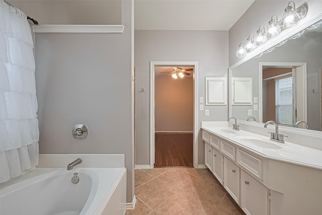 bathroom with a bath, a ceiling fan, tile patterned flooring, and a sink