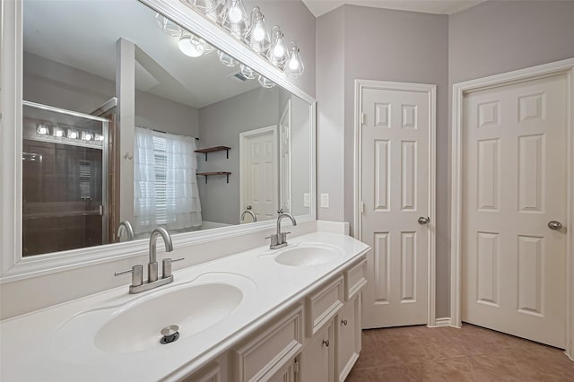 bathroom with tile patterned floors, an enclosed shower, a sink, and double vanity