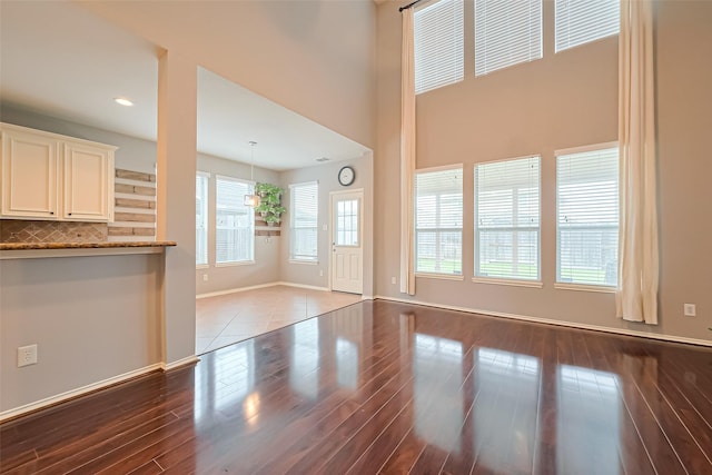 unfurnished living room with baseboards, wood finished floors, visible vents, and recessed lighting