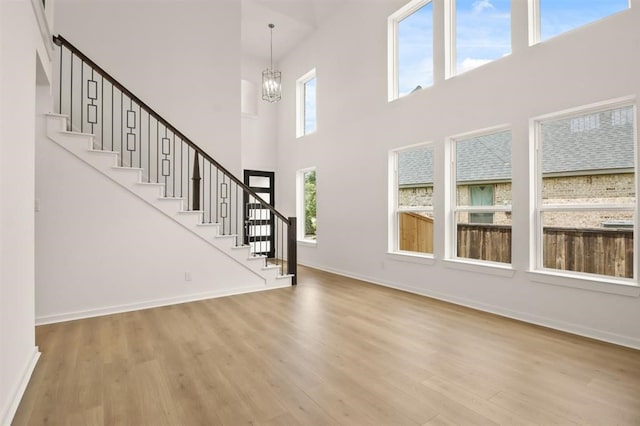 122 Canary Island Cir, Montgomery, TX 77316 - foyer with wood finished floors, a chandelier, stairway, a high ceiling, and baseboards