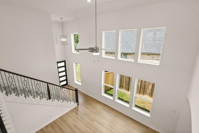 122 Canary Island Cir, Montgomery, TX 77316 - unfurnished living room with a high ceiling, wood finished floors, ceiling fan, a chandelier, and stairway