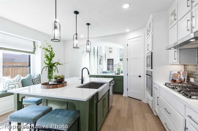 122 Canary Island Cir, Montgomery, TX 77316 - kitchen with appliances with stainless steel finishes, light countertops, recessed lighting, light wood-style floors, and a kitchen breakfast bar