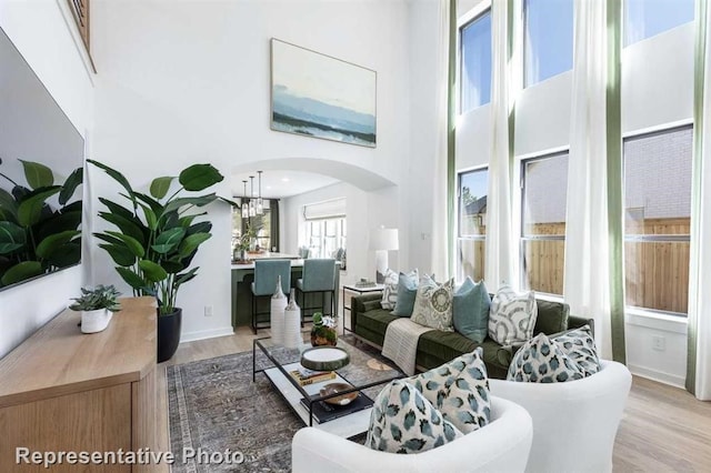 122 Canary Island Cir, Montgomery, TX 77316 - living area featuring a towering ceiling, wood finished floors, arched walkways, and a chandelier