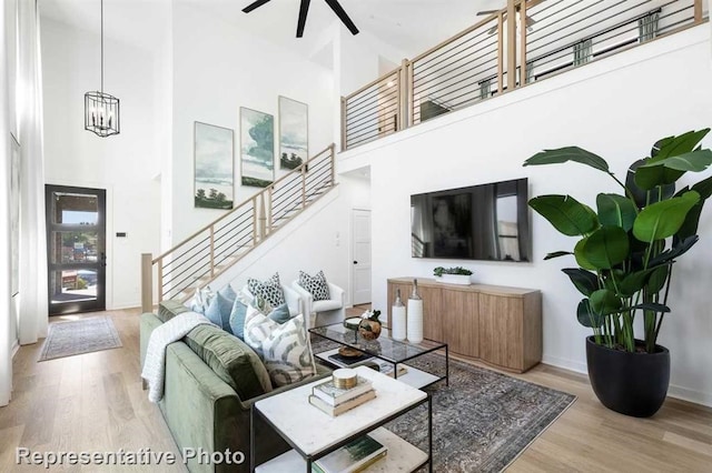122 Canary Island Cir, Montgomery, TX 77316 - living area featuring a high ceiling, stairs, wood finished floors, ceiling fan, and a chandelier
