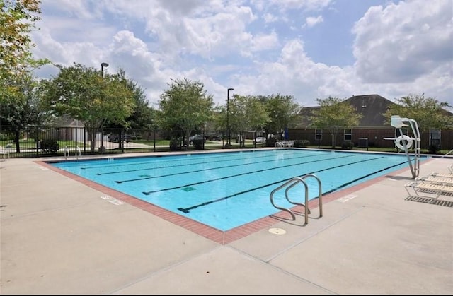 community pool featuring fence and a patio area