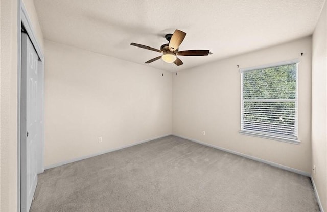 unfurnished bedroom with light colored carpet, baseboards, and a closet