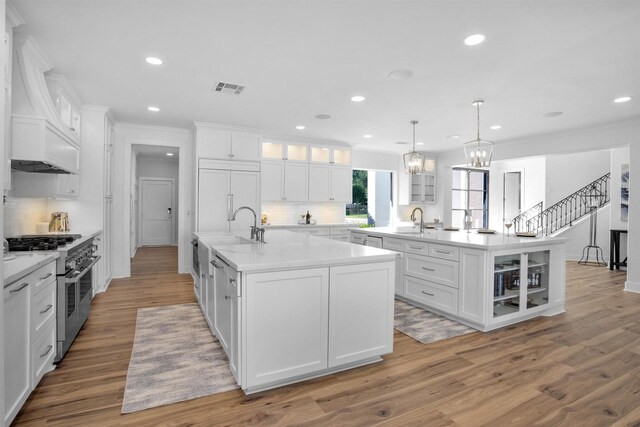 16059 Walden Rd, Conroe, TX 77356 - kitchen with a sink, high end appliances, a center island with sink, visible vents, and tasteful backsplash