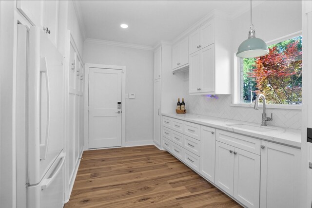16059 Walden Rd, Conroe, TX 77356 - kitchen featuring freestanding refrigerator, ornamental molding, a sink, white cabinetry, and wood finished floors