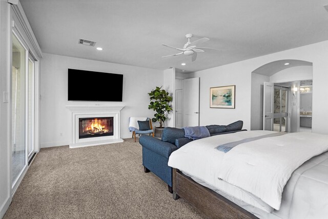 16059 Walden Rd, Conroe, TX 77356 - bedroom featuring arched walkways, recessed lighting, a glass covered fireplace, and visible vents