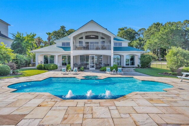16059 Walden Rd, Conroe, TX 77356 - back of property featuring a patio, stucco siding, a pool with connected hot tub, a lawn, and a balcony