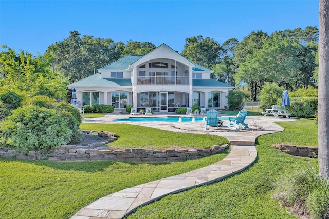 16059 Walden Rd, Conroe, TX 77356 - back of house with a balcony, a yard, an outdoor pool, a patio area, and stucco siding
