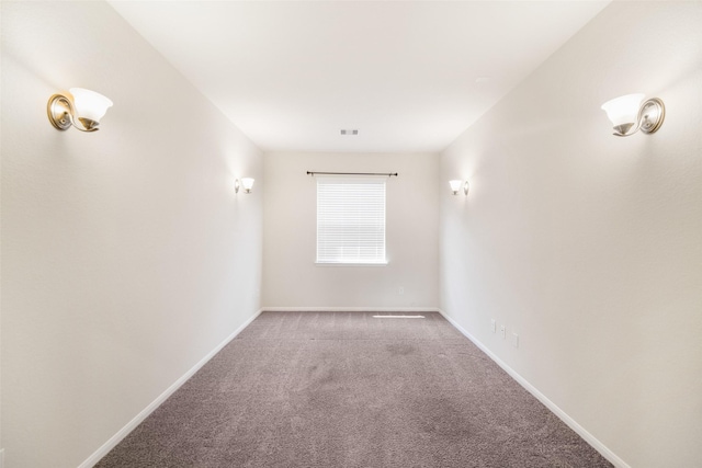 unfurnished room featuring carpet, visible vents, and baseboards
