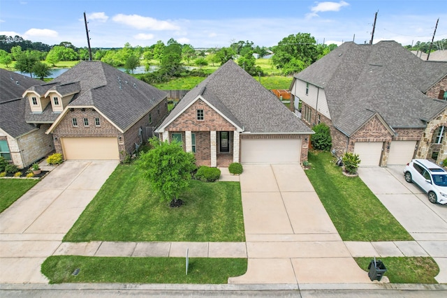 view of front of house featuring brick siding, roof with shingles, driveway, and a front yard