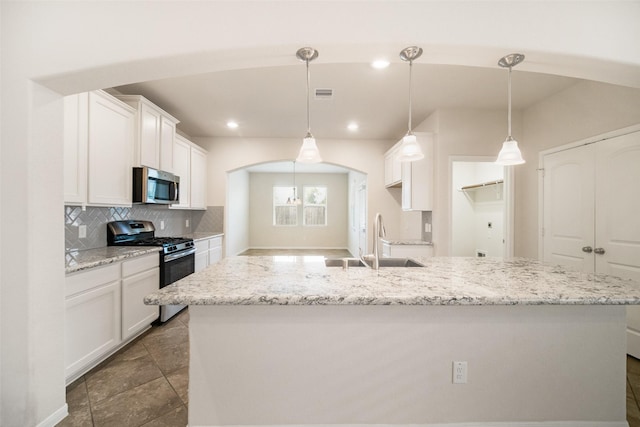 kitchen featuring visible vents, white cabinetry, stainless steel appliances, and a sink