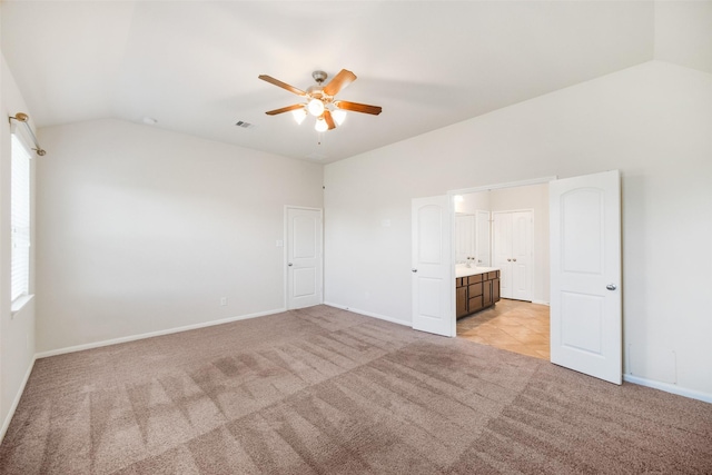 unfurnished bedroom with baseboards, lofted ceiling, light colored carpet, and ceiling fan