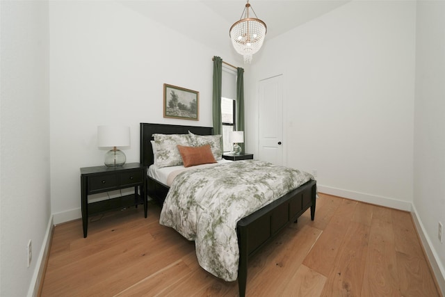 14924 Scarlet Branch Dr, Conroe, TX 77302 - bedroom featuring baseboards, a notable chandelier, and light wood-style floors