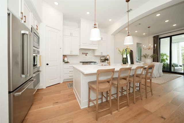 14924 Scarlet Branch Dr, Conroe, TX 77302 - kitchen with recessed lighting, light wood finished floors, stainless steel appliances, light countertops, and tasteful backsplash