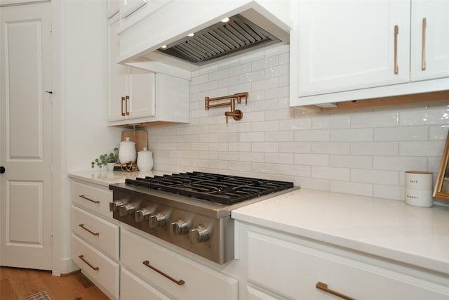 14924 Scarlet Branch Dr, Conroe, TX 77302 - kitchen featuring white cabinets, stainless steel gas cooktop, light countertops, and custom range hood