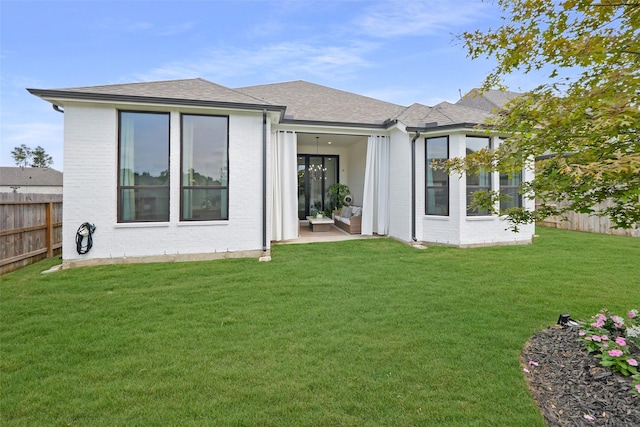 14924 Scarlet Branch Dr, Conroe, TX 77302 - back of house with brick siding, a yard, a shingled roof, and fence