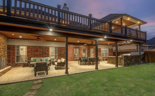 14911 Hurst Point Ln, Houston, TX 77049 - back of house at dusk featuring a balcony, ceiling fan, outdoor lounge area, brick siding, and a patio area