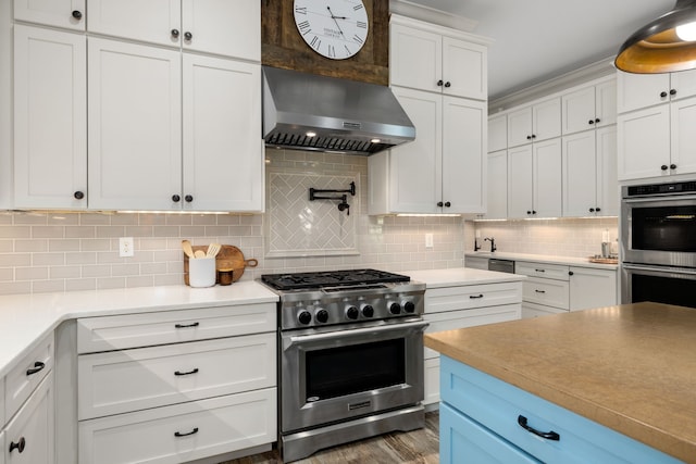 kitchen featuring tasteful backsplash, stainless steel appliances, light countertops, white cabinets, and range hood