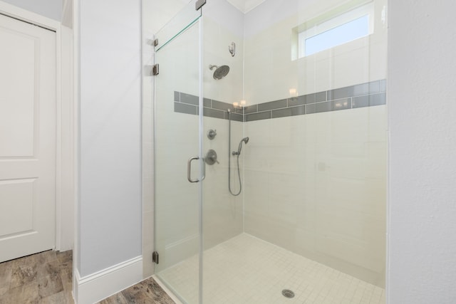 bathroom with wood finished floors and a stall shower