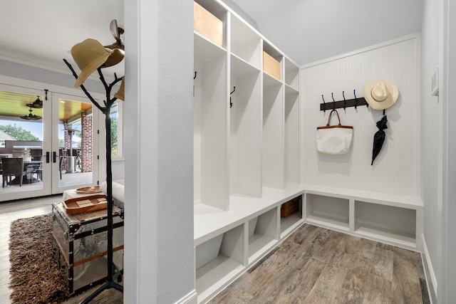 mudroom with wood finished floors, ornamental molding, and french doors