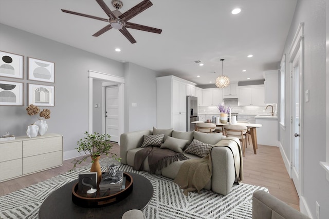 living area featuring baseboards, recessed lighting, light wood-style floors, and ceiling fan