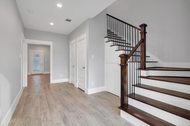stairs featuring visible vents, baseboards, wood finished floors, and recessed lighting