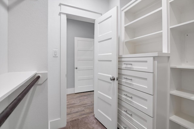 spacious closet with dark wood finished floors