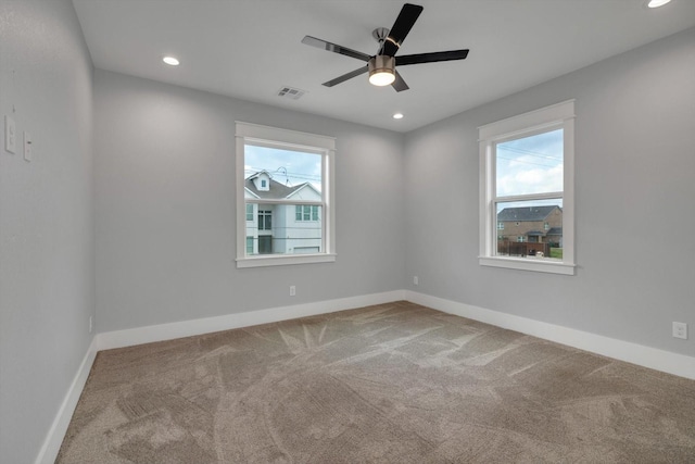 spare room featuring recessed lighting, plenty of natural light, visible vents, and carpet flooring