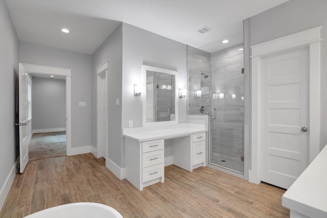 bathroom with baseboards, recessed lighting, wood finished floors, a shower stall, and vanity
